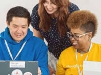 Formation IA Google : groupe diversifié travaillant sur des ordinateurs portables, souriant et collaborant.