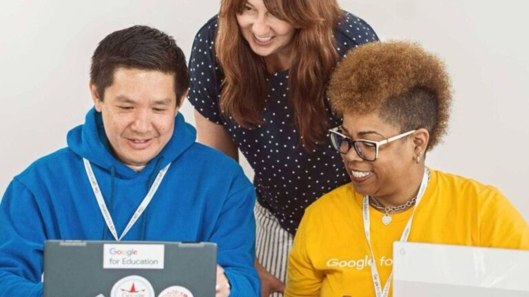 Formation IA Google : groupe diversifié travaillant sur des ordinateurs portables, souriant et collaborant.