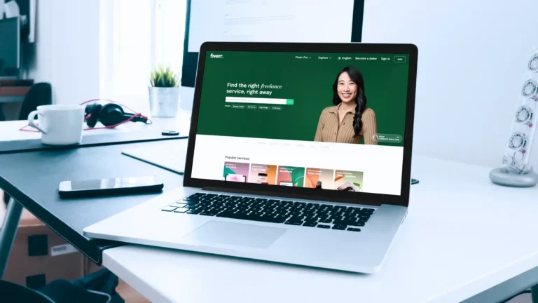 Ordinateur portable affichant la page d'accueil Fiverr, avec une femme souriante et la recherche de services IA et experts. fiverr.webp.