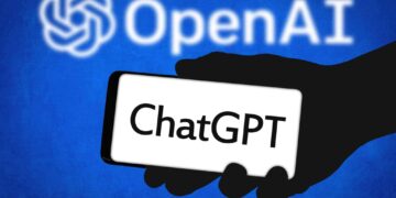 Image de ChatGPT sur un téléphone, logo OpenAI en arrière-plan. Génération d'images par IA, compétition avec Google.