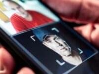 Recognize an AI video: man holding a phone with facial analysis. Guide to detecting fakes.