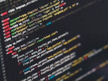 Colorful lines of PHP and HTML code on a dark screen, representing the source code at the heart of AI and free software.