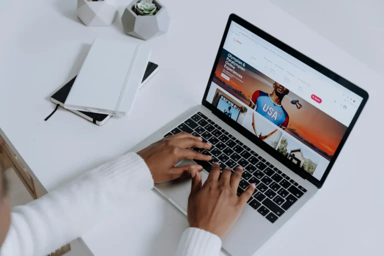 Mains tapant sur un ordinateur portable argenté, écran affichant un navigateur web. Scène de productivité, évoquant les extensions IA pour optimiser le travail.