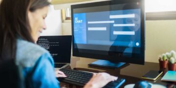 Une experte en IA rédige des prompts complexes sur son poste de travail, interagissant avec un système de chat IA pour optimiser les réponses.