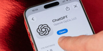 Doigt ouvrant l'application ChatGPT d'OpenAI sur iPhone, écran affichant le logo et le bouton 'Open'. Maîtriser l'IA.