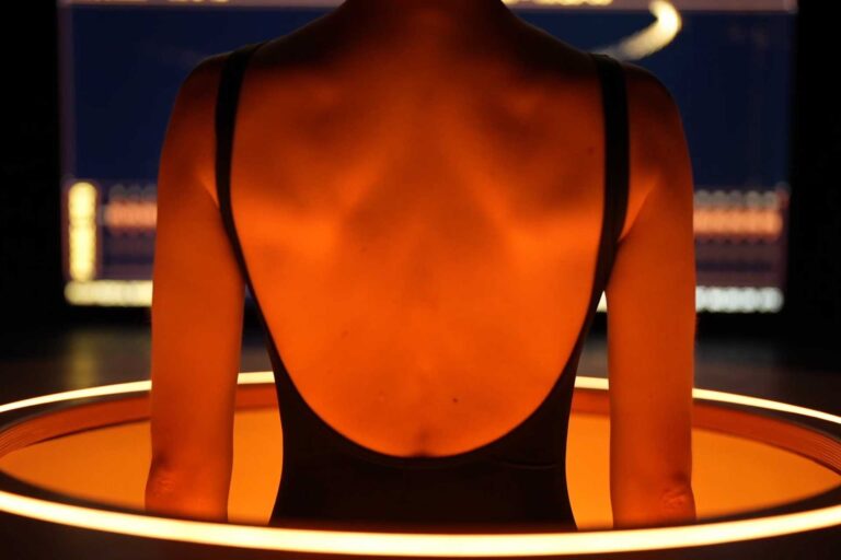 Dos d'une personne scannée par un appareil futuriste orange lumineux, symbolisant le Midjourney Scanner et l'IA pour la santé.