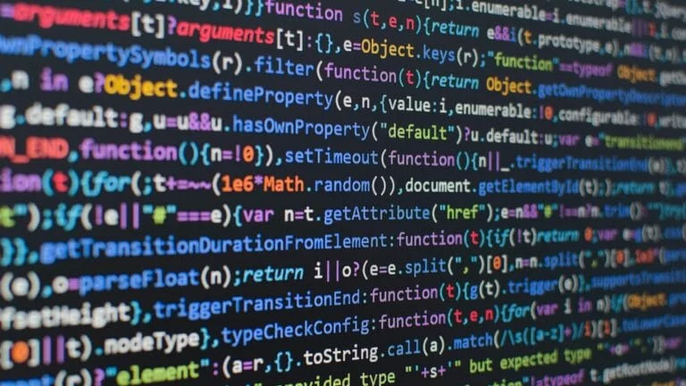 Gros plan sur du code informatique coloré, évoquant le "code manuel" et la "syntaxe" qui agonise pour les développeurs.