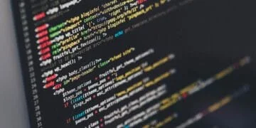 Lignes de code PHP et HTML colorées sur un écran sombre, affichant du code source pour le développement web. Représente l'intelligence logicielle.